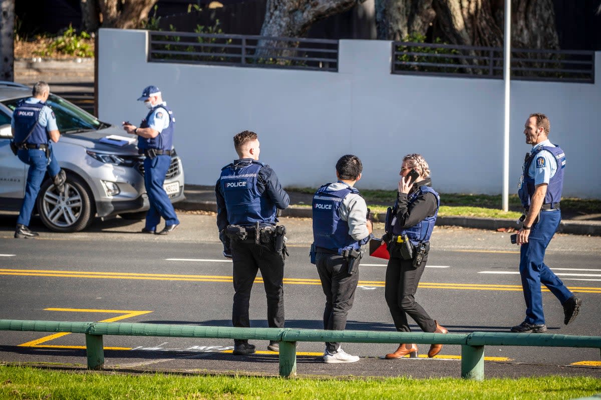 Police set up cordons and search area around a suburb of Auckland following reports of multiple stabbings (AP)