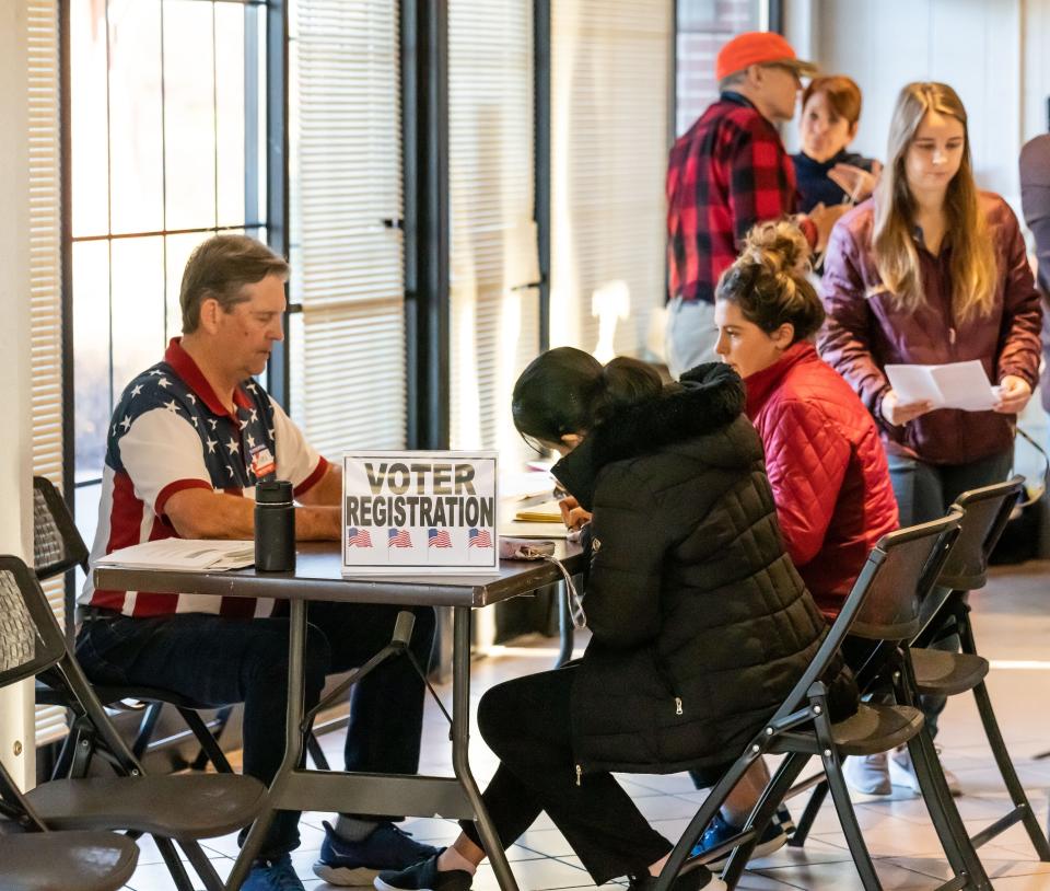 A poll worker assists City of Waukesha voters with registration at the Frame Park Rotary building early Tuesday. The polling site had a steady stream of voters since opening at 7 a.m.