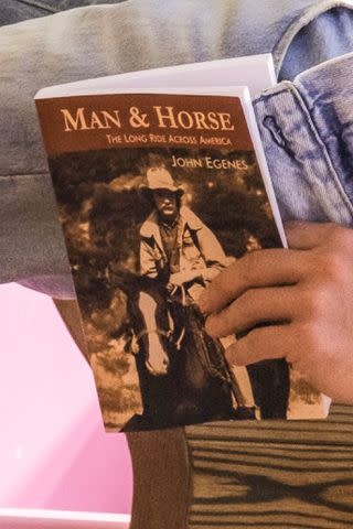 <p>Jaap Buitendijk</p> Ryan Gosling holds a copy of John Egenes' 'Man & Horse: The Long Ride Across America'