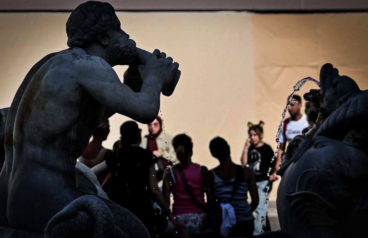 People stand next to a fountain at Piazza Navona in central Rome, on July 14, 2023, as Italy is hit by a heatwave (AFP via Getty Images)