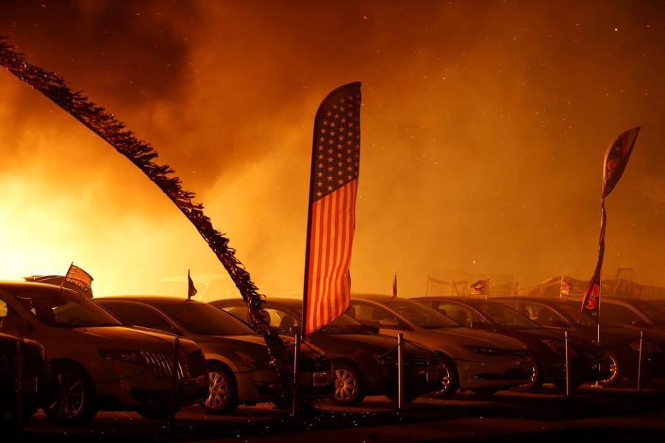 An American flag is seen at an engulfed car dealership during the Camp Fire in Paradise, Calif., on Nov. 8.