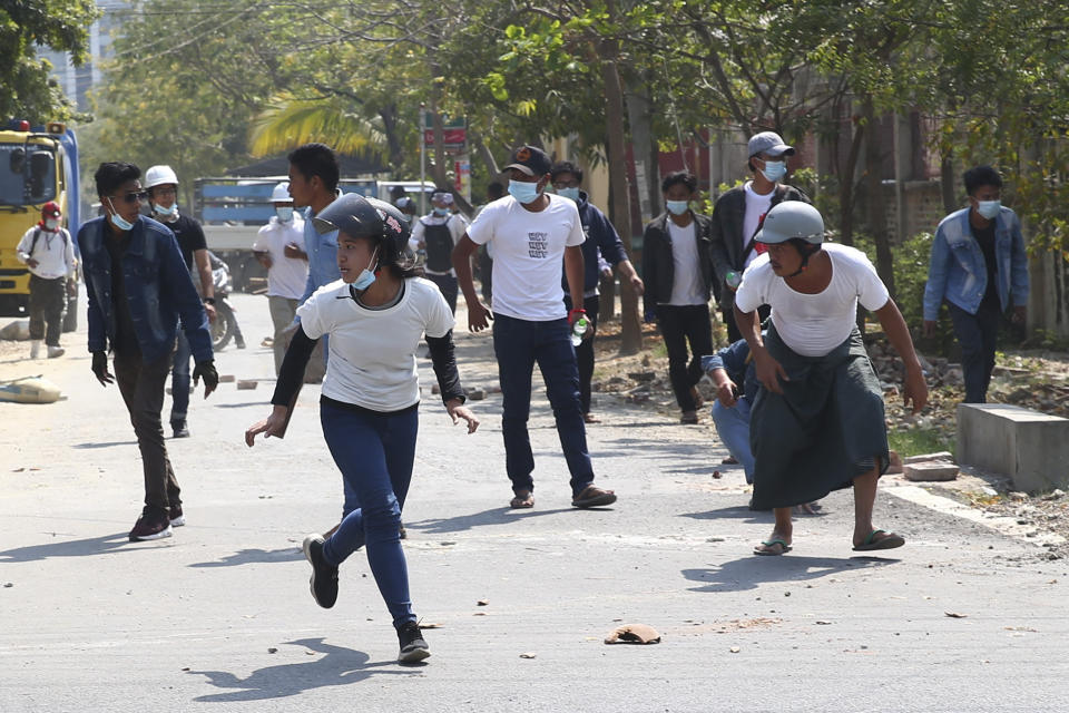 In this Feb. 28, 2021, file photo, protesters run as police fire tear gas during a protest against the military coup in Mandalay, Myanmar. Myanmar's security forces have killed scores of demonstrators protesting a coup. The outside world has responded so far with tough words, a smattering of sanctions and little else. (AP Photo, File)