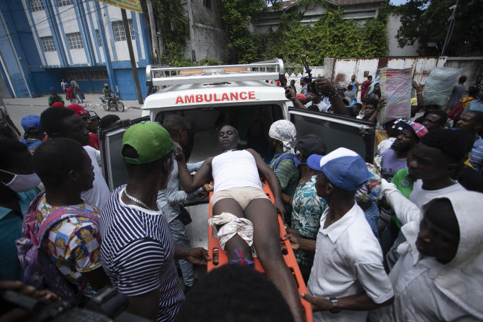 A protester who was shot by the police in the leg is moved to an ambulance during a protest demanding the resignation of prime Minister Ariel Henry in the Petion-Ville area of Port-au-Prince, Haiti, Monday, Oct. 3, 2022. (AP Photo/Odelyn Joseph)