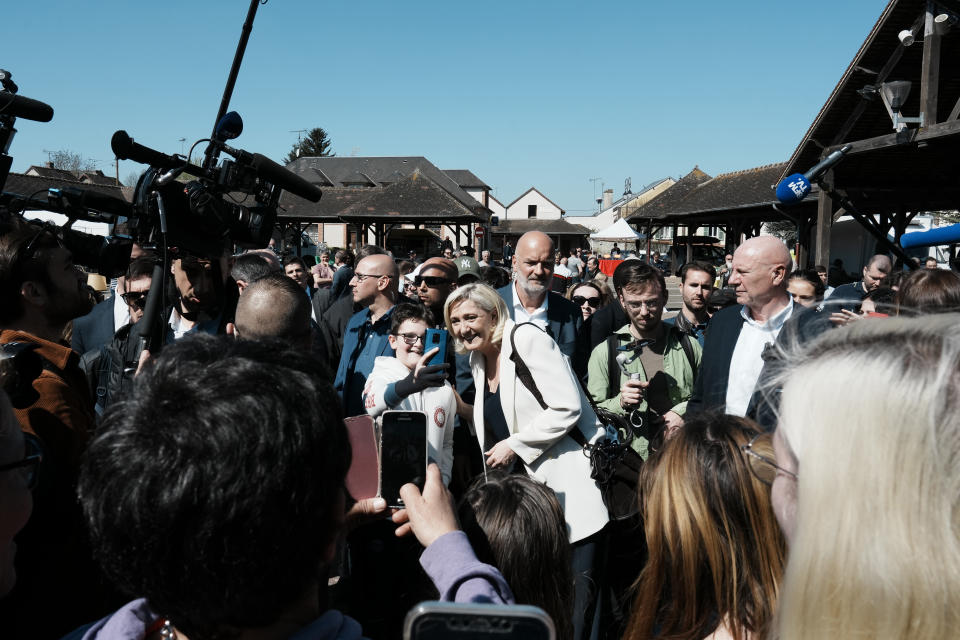French far-right leader Marine Le Pen poses for a selfie as she campaigns in Saint-Remy-sur-Avre, western France, Saturday, April 16, 2022. Marine Le Pen is trying to unseat centrist President Emmanuel Macron, who has a slim lead in polls ahead of France's April 24 presidential runoff election. (AP Photo/Thibault Camus)
