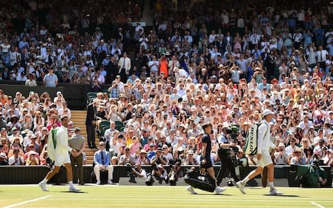 Serbia's Novak Djokovic (L) and South Africa's Kevin Anderson arrive on centre court to play the men's singles final match on the thirteenth day of the 2018 Wimbledon Championships at The All England Lawn Tennis Club in Wimbledon, southwest London, on July 15, 2018 - Credit: AFP