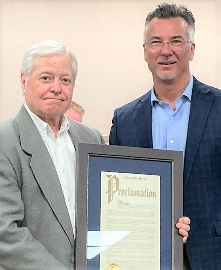 Larry Finch, left, and Twinsburg Mayor Ted Yates hold a proclamation given to Finch upon his retirement as director of planning and community development.