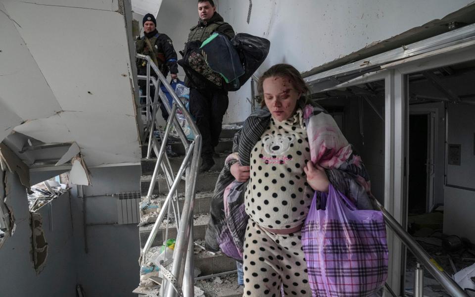 An injured pregnant woman walks downstairs the maternity hospital bombed by Russia - Evgeniy Maloletka /AP
