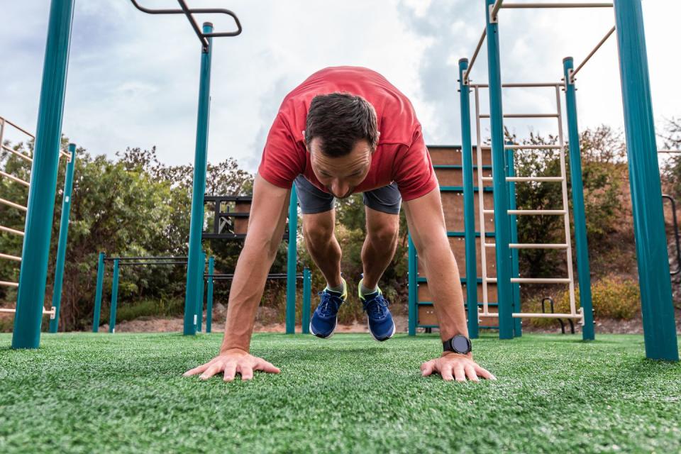 athletic fitness man doing burpee exercise fit male in gym exercise outdoors healthy lifestyle strength cardio on the sport ground