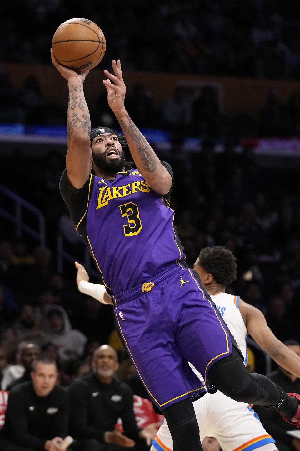 Los Angeles Lakers forward Anthony Davis, left, shoots as Oklahoma City Thunder guard Aaron Wiggins defends during the first half of an NBA basketball game Friday, March 24, 2023, in Los Angeles. (AP Photo/Mark J. Terrill)