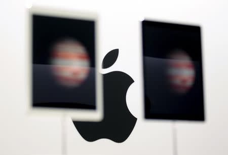 The Apple logo is seen behind new Apple iPad Pros on display during an Apple media event in San Francisco, California, September 9, 2015. REUTERS/Beck Diefenbach