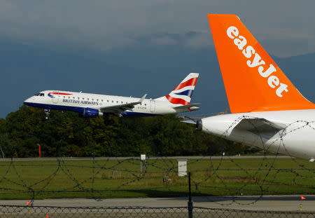 FILE PHOTO - A British Airways Embraer ERJ-170STD aircraft lands next to a EasyJet plane ready for take off at Cointrin airport in Geneva, Switzerland September 26, 2017. REUTERS/Denis Balibouse