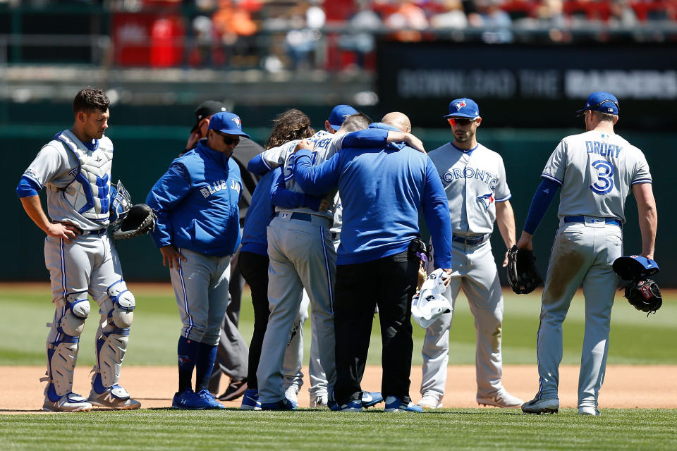 OAKLAND, CA - APRIL 20: Starting pitcher Matt Shoemaker #34 of the Toronto Blue Jays is assisted from the field after a collision while getting the out of Matt Chapman #26 of the Oakland Athletics in the bottom of the third inning at Oakland-Alameda County Coliseum on April 20, 2019 in Oakland, California. (Photo by Lachlan Cunningham/Getty Images)