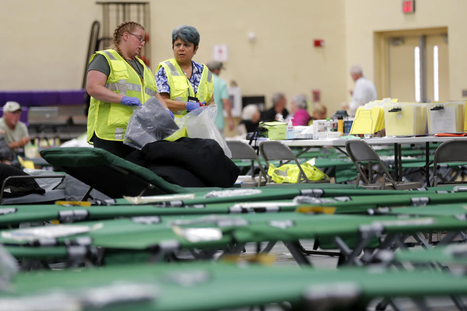 Florida Department of Health staffers set up beds at an evacuation shelter for people with special needs, in preparation for Hurricane Dorian, at Dr. David L. Anderson Middle School in Stuart, Fla., Sunday, Sept. 1, 2019. Some coastal areas are under a mandatory evacuation since the path of the storm is still uncertain. (AP Photo/Gerald Herbert)