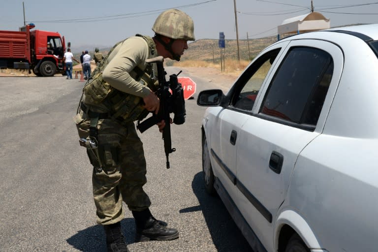 A Turkish soldier checks cars at a checkpoint in Diyarbakir in the Kurdish-dominated southeast of the country on July 26, 2015