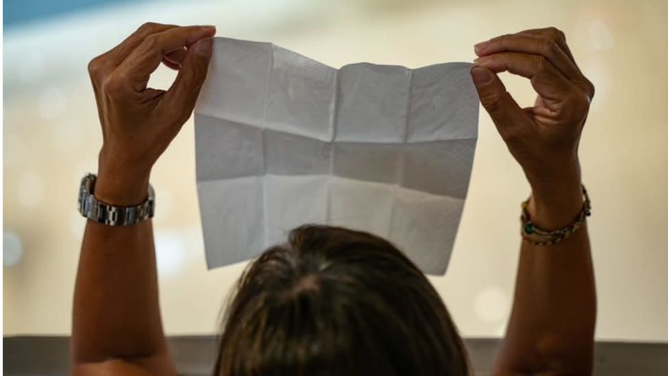 Una mujer sostiene un papel en blanco durante protestas en Hong Kong