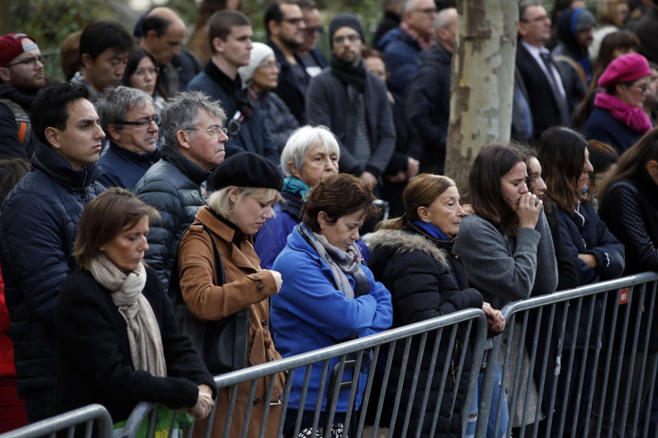 People pay respect to the victims during a ceremony marking the third anniversary of the Paris attacks of November 2015 in which 130 people were killed, in Paris, Tuesday, Nov. 13, 2018. France's interior minister says French security services have foiled six terror attacks this year, as the country marks three years since gun and bomb attacks in Paris killed 130 people. (AP Photo/Christophe Ena)