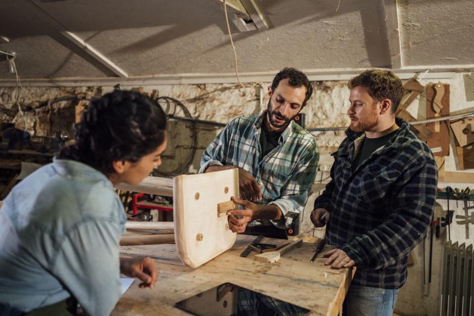 carpenter and his apprentice working with sustainable locally sourced wood in a workshop in the north east of england they are making handcrafted furniture and they are a family business their current project is a chair