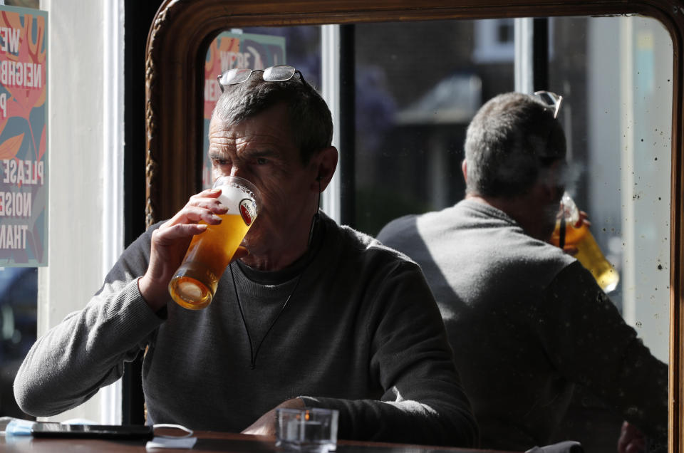 A man drinks a pint of beer in the Black Lion pub in Hammersmith in London, Monday, May 17, 2021. Drinks were raised in toasts and reunited friends hugged each other as thousands of U.K. pubs and restaurants opened Monday for indoor service for the first time since early January. Yet the prime minister sounded a cautious tone, warning about a more contagious COVID-19 variant first discovered in India that threatens reopening plans. (AP Photo/Frank Augstein)