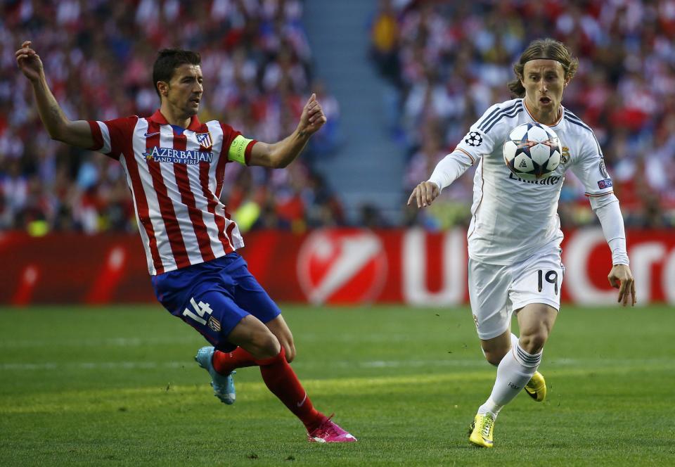 Real Madrid's Luka Modric (R) controls the ball as Atletico Madrid's Gabi (L) moves in during their Champions League final soccer match at the Luz Stadium in Lisbon May 24, 2014. REUTERS/Kai Pfaffenbach (PORTUGAL - Tags: SPORT SOCCER)