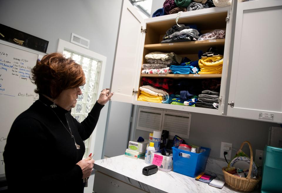 Anne Marie Noble, executive director of The Haven of Portage County, opens a cabinet of women's pajamas that are given to residents at the shelter.