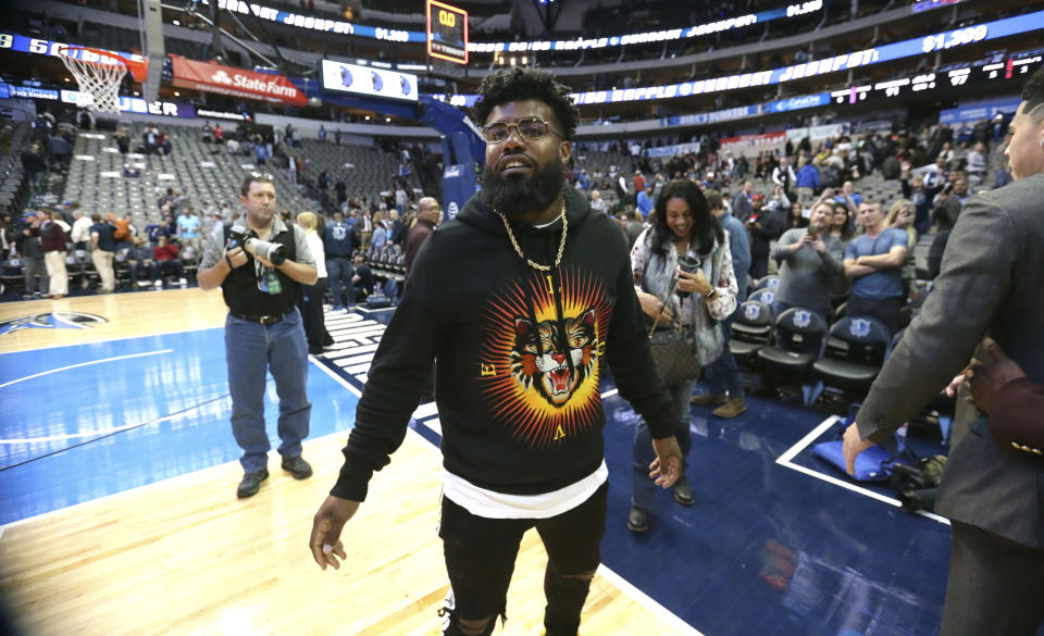 Dallas Cowboys running back Ezekiel Elliott walks the floor after an NBA basketball game between the Phoenix Suns and Dallas Mavericks in Dallas, Monday, Dec. 18, 2017.(AP Photo/LM Otero)