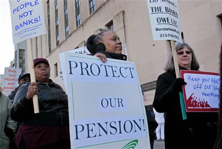 Detroit city workers and retirees carry signs protesting against cuts in their city pensions and health care benefits during a protest against the city's municipal bankruptcy filing, outside the Federal courthouse in Detroit, Michigan October 23, 2013. REUTERS/Rebecca Cook