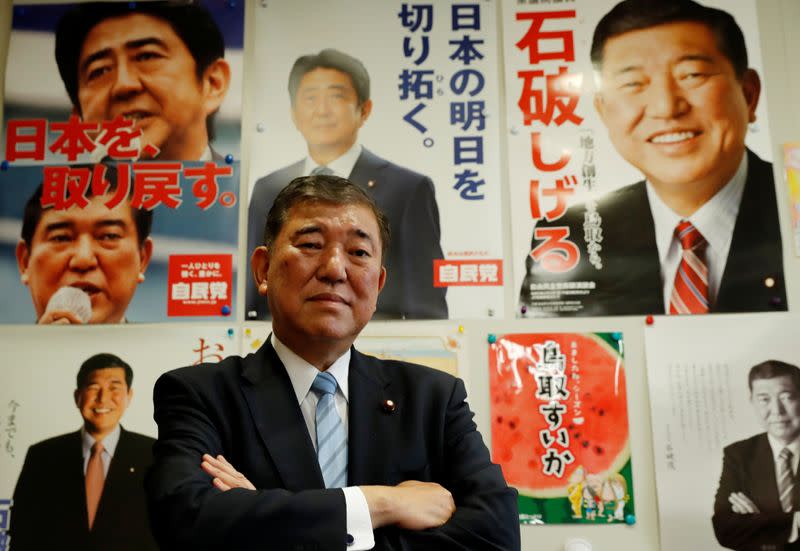 Japan's ruling Liberal Democratic Party lawmaker Shigeru Ishiba poses in front of posters at his office after an interview with Reuters in Tokyo