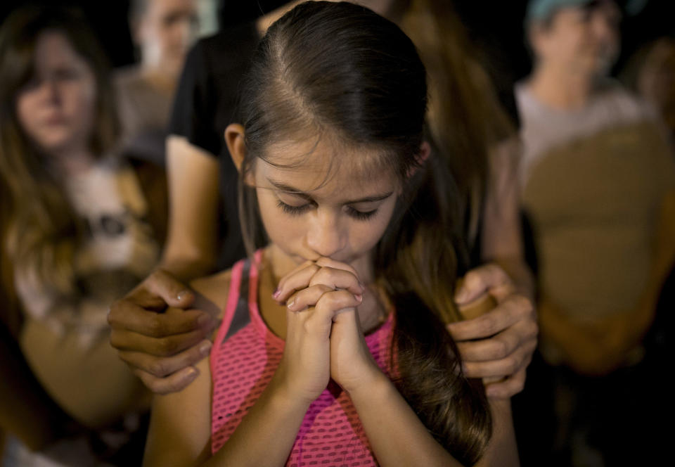 <p>Sophia Martinez, 9, prays at a memorial service for the victims of Sunday’s church shooting in Sutherland Springs, Texas, Monday, Nov. 6, 2017. (Photo: Jay Janner/Austin American-Statesman via AP) </p>