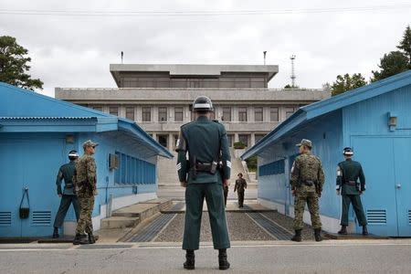 South Korean soldiers look towards the North Korean side as a North Korean solder approaches the U.N. truce village building that sits on the border of the Demilitarized Zone (DMZ), the military border separating the two Koreas, during the visit of U.S. Secretary of Defense Chuck Hagel, in Panmunjom, South Korea September 30, 2013. REUTERS/Jacquelyn Martin/Pool