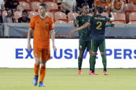 Houston Dynamo midfielder Matias Vera (22) walks off as Portland Timbers Jeremy Ebobisse, middle, and Jose van Rankin (2) celebrate the goal by Ebobisse during the second half of an MLS soccer match Wednesday, June 23, 2021, in Houston. (AP Photo/Michael Wyke)