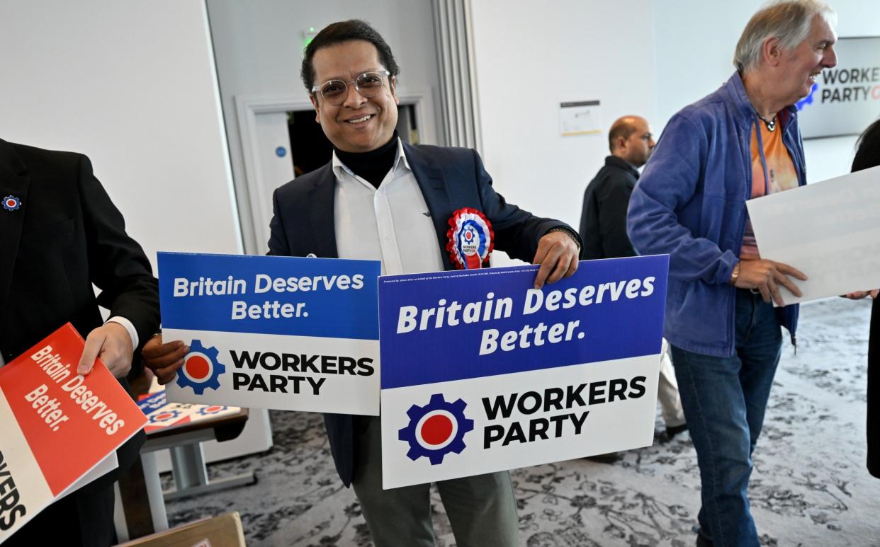 A supporter hands out placards at the Workers Party of Britain manifesto launch, in Manchester on Wednesday