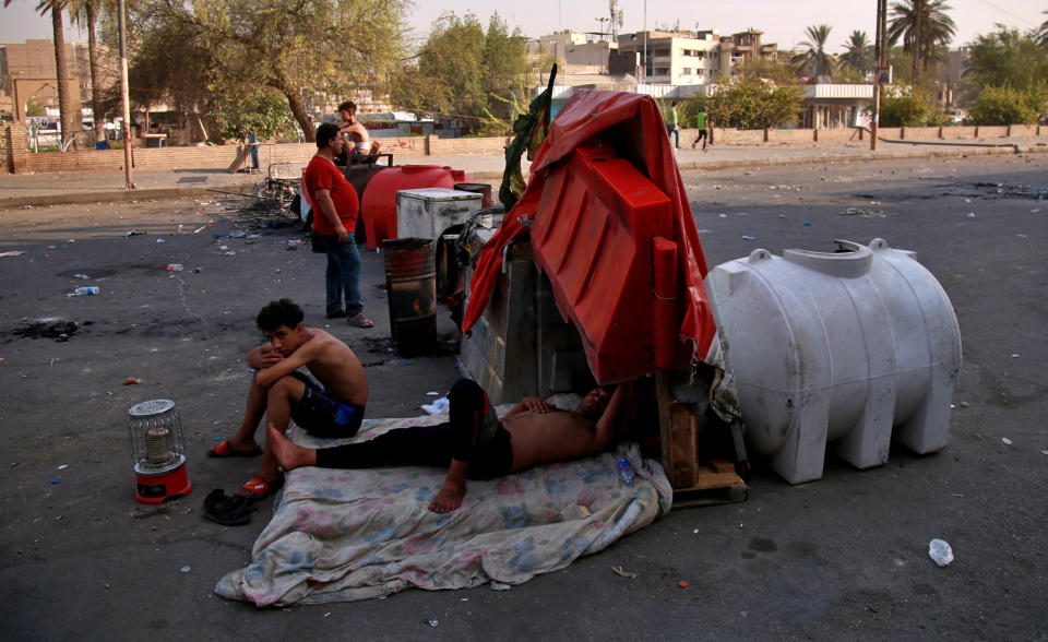 Anti-government protesters gather by barriers near Tahrir square, Baghdad, Iraq, Monday, July, 27, 2020. Fresh violence erupted between demonstrators and Iraqi security forces in central Baghdad, human rights monitors and Iraqi security and health officials said on Monday, following months of quiet in the wake of the coronavirus pandemic. (AP Photo/Khalid Mohammed)