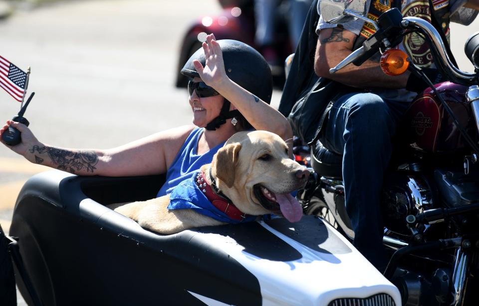 Maria Michaels of Waynesburg, with dog, Max, waves to onlookers Monday during the Canton Memorial Day Parade on Tuscarawas Street W.