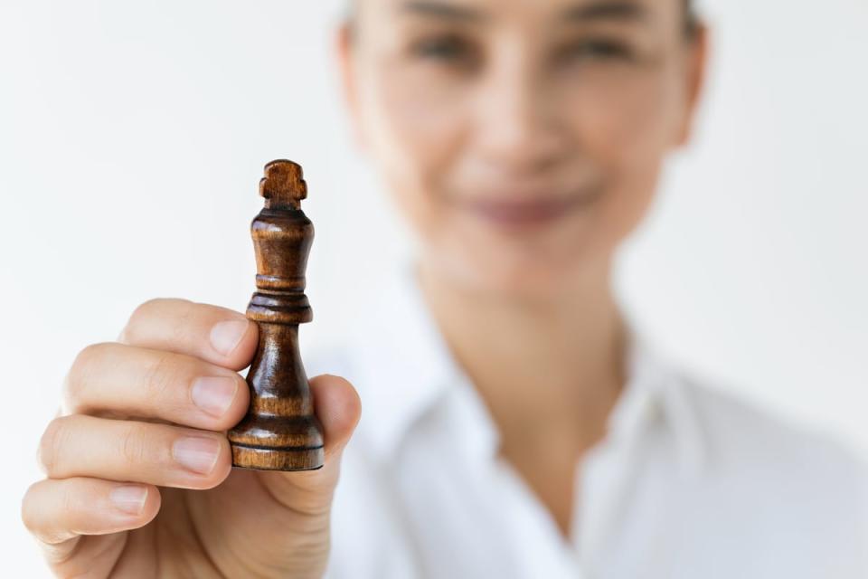 A person holding a chess piece that is a King.