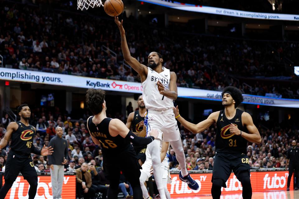 Brooklyn Nets forward Kevin Durant shoots against Cavaliers forward Cedi Osman (16) and center Jarrett Allen (31) during the second half, Monday, Dec. 26, 2022, in Cleveland.