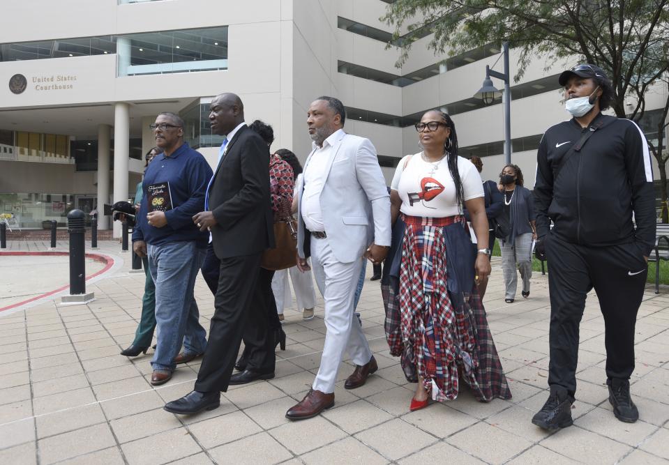 FILE - Attorney Ben Crump, second from left, walks with Ron Lacks, left, Alfred Lacks Carter, third from left, both grandsons of Henrietta Lacks, and other descendants of Lacks, outside the federal courthouse in Baltimore, Oct. 4, 2021. The family of Henrietta Lacks is settling a lawsuit against a biotechnology company it accuses of improperly profiting from her cells. Their federal lawsuit in Baltimore claimed Thermo Fisher Scientific has made billions from tissue taken without the Black woman’s consent from her cervical cancer tumor. (AP Photo/Steve Ruark, file)