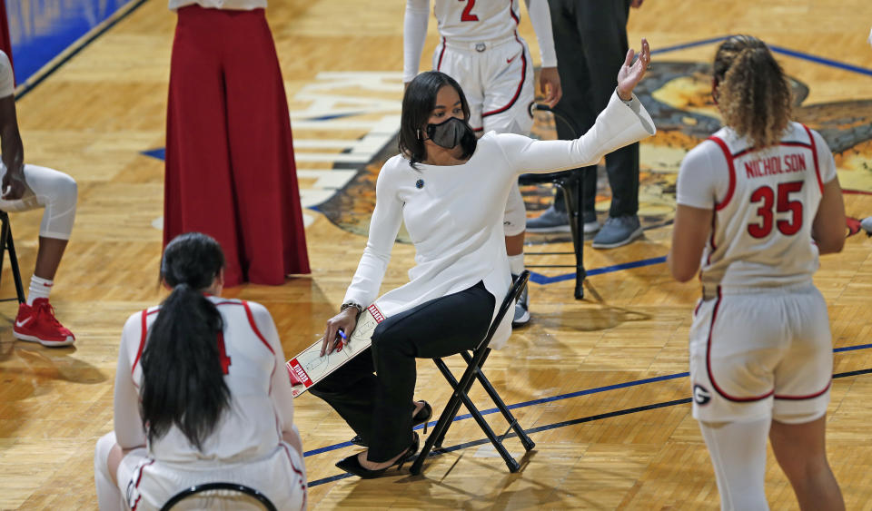 Georgia head coach Joni Taylor holds her meeting respecting social distancing during the first half of a college basketball game in the first round of the women's NCAA tournament at the Greehey Arena in San Antonio, Texas, Monday, March 22, 2021. (AP Photo/Ronald Cortes)