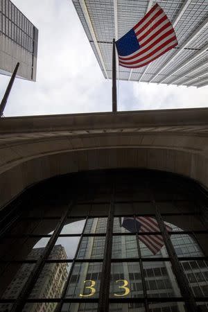 The American flag hangs over 33 Liberty St. The New York Federal Reserve Bank in New York's financial district March 25, 2015. REUTERS/Brendan McDermid