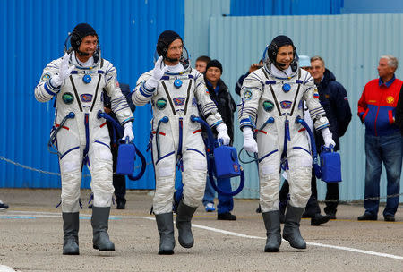 The International Space Station (ISS) crew members (L to R)Shane Kimbrough of the U.S., Sergey Ryzhikov and Andrey Borisenko of Russia walk after donning space suits at the Baikonur cosmodrome, Kazakhstan, October 19, 2016. REUTERS/Shamil Zhumatov