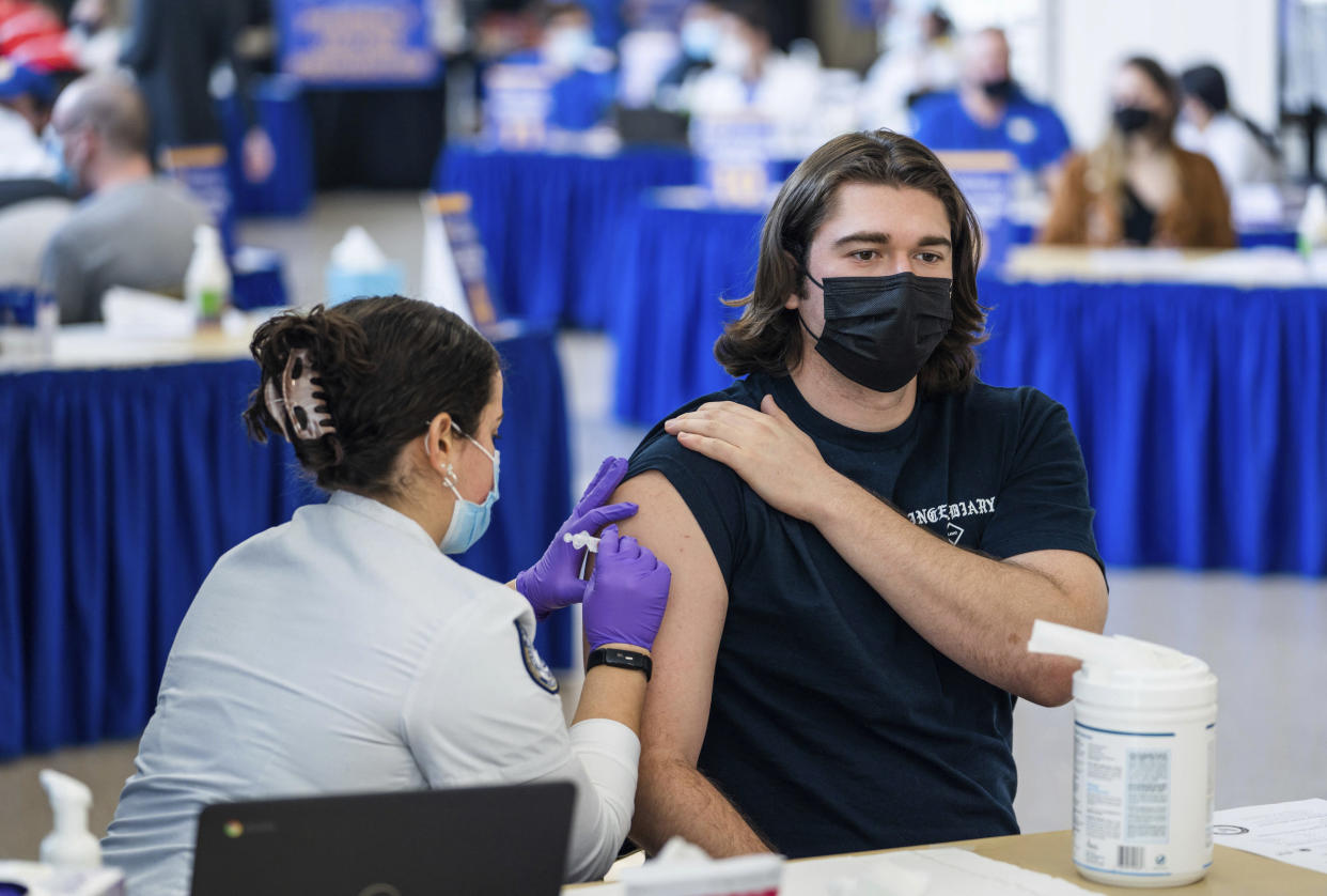 In the file photo dated Jan. 12, 2022, Pitt student Michael Burke, 21, gets a COVID-19 booster shot from nursing student Colette Sayegh at the Peterson Events Center in Oakland, Pa. (Andrew Rush/Pittsburgh Post-Gazette via AP)
