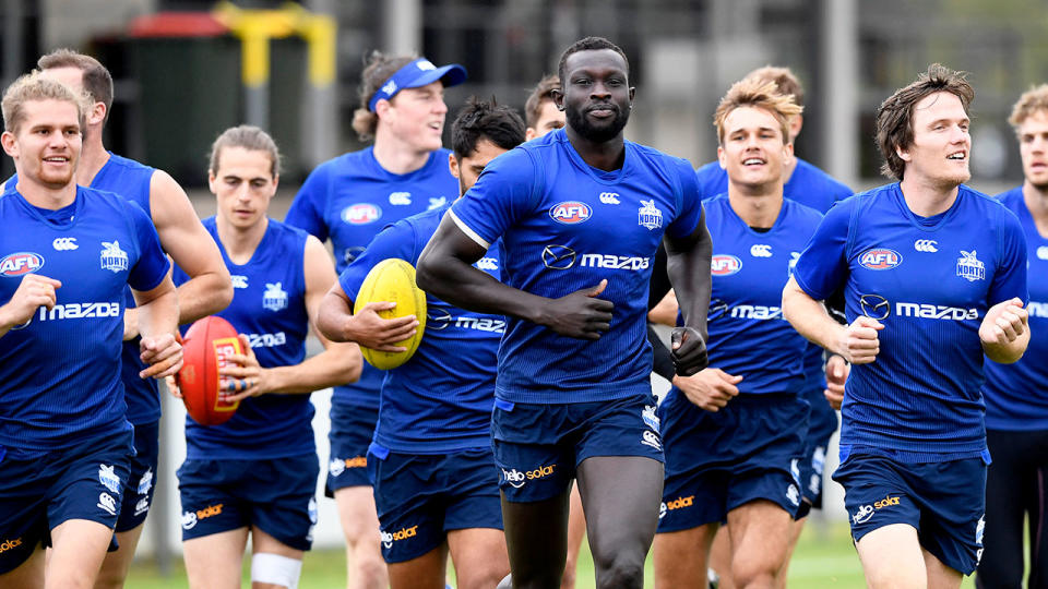 Seen here, Majak Daw runs with teammates at Kangaroos training.