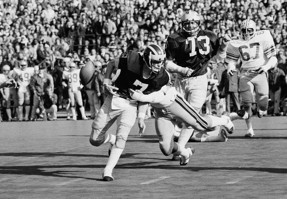 Michigan quarterback Rick Leach (7) fumbles as he is wrapped up by Ohio State’s Scott Dannelley during the 1975 game in Ann Arbor, Michigan. The Buckeyes won 21-14.