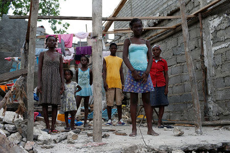 Roseline Charles (R), 57, poses for a photograph next to her relatives in their destroyed house after Hurricane Matthew hit Jeremie, Haiti, October 15, 2016. "As you can see, my house was completely destroyed, we lost everything. None of us died during the hurricane but we are homeless now," said Charles. REUTERS/Carlos Garcia Rawlins