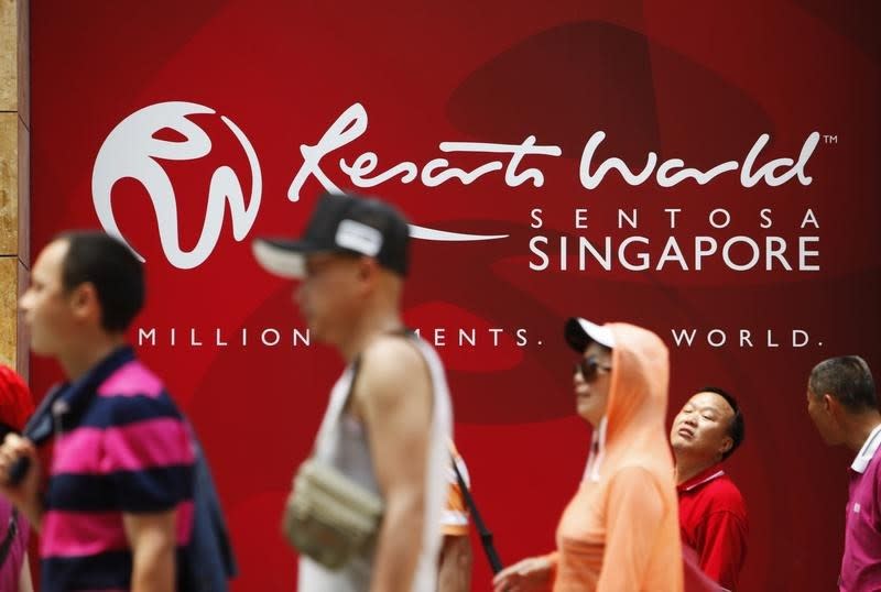 People walk past a logo of Genting Singapore's Resorts World Sentosa in Singapore, April 29, 2013. REUTERS/Edgar Su