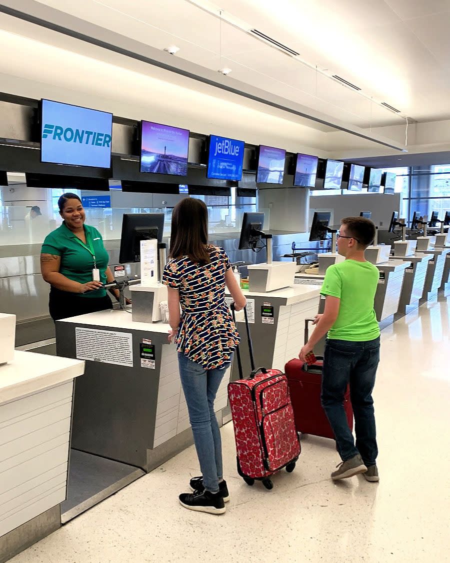 two passengers checking bags at frontier counter