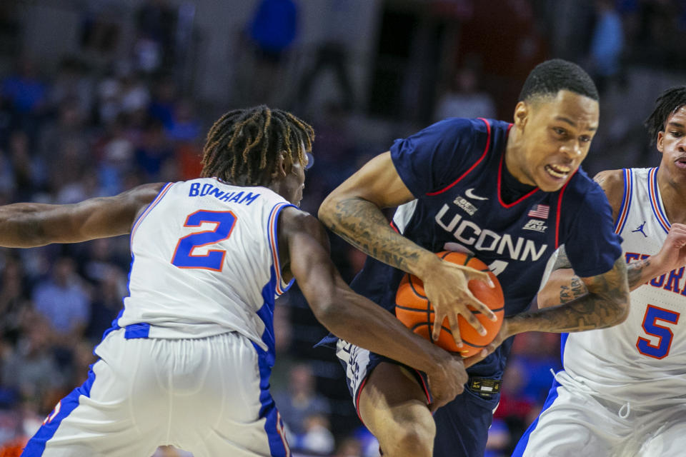 Connecticut guard Andre Jackson Jr. (44), center, gets pressure from Florida guard Trey Bonham (2) and guard Will Richard (5) during the first half of an NCAA college basketball game Wednesday, Dec. 7, 2022, in Gainesville, Fla. (AP Photo/Alan Youngblood)