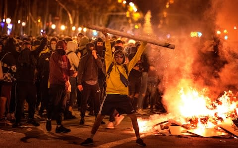 Protesters make barricades in the street during clashes with police in Barcelona - Credit: AP