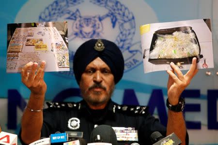 Amar Singh, head of Malaysia's Commercial Crime Investigation Department (CCID), displays photos of items from a raid during a news conference in Kuala Lumpur, Malaysia June 27, 2018. REUTERS/Lai Seng Sin