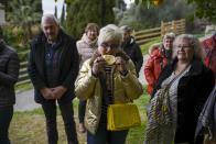 A visitor tastes a lemon during a guided tour at the la Casetta garden in Menton, France, Friday, March 1, 2024. The mild climate — from a protective mountain range, proximity to the sea and steady sunshine with moderate rain during winter months — and sandstone-rich soil give the Menton lemon its distinct flavor: acidic, but neither bitter nor sweet, and with a lemongrass scent in its zest. (AP Photo/Daniel Cole)