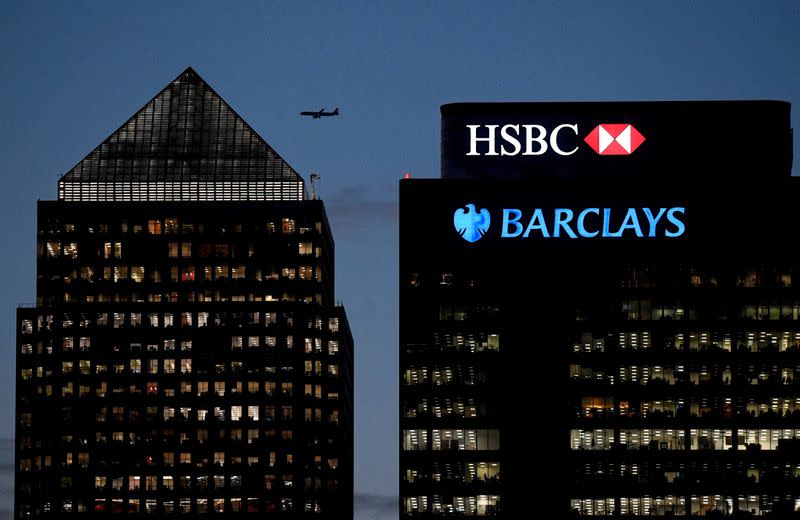 FILE PHOTO: Workers are seen in offices of HSBC and Barclays bank in the Canary Wharf financial district at dusk in London